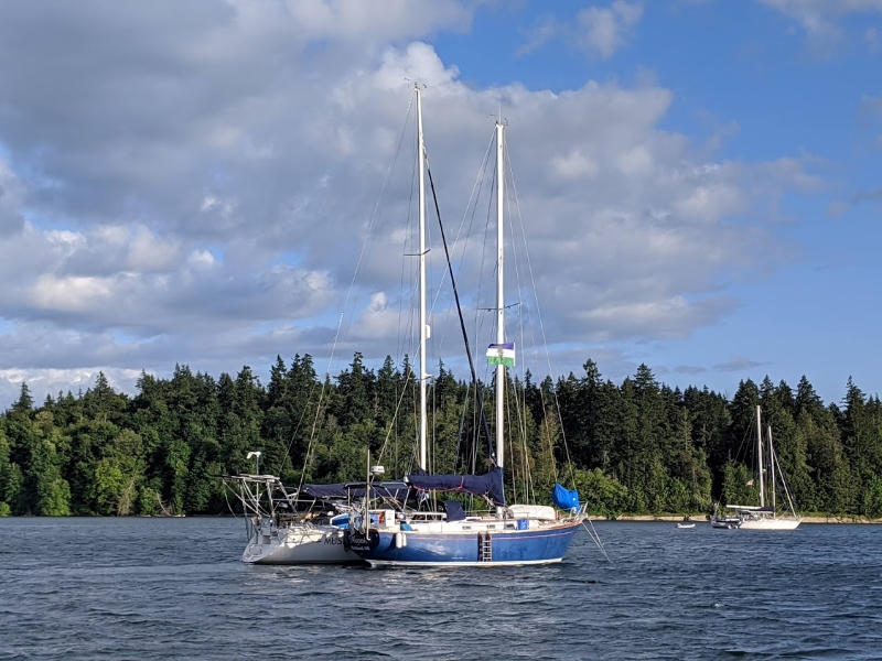 Two cruising sailboat sit rafted up at anchor at Penrose Point State Park in July 2020