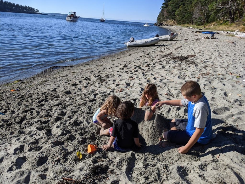Boat kids playing on a rare sandy beach in the San Juan Islands